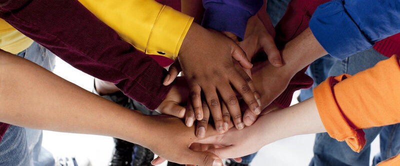 Diverse Teenagers. Putting their hands together.